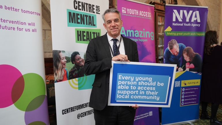 minister jess smith poses with youth access pledge board