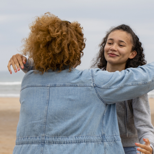 young person hugging on beach